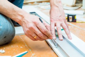 hands of a general contractor measuring 