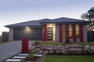 a quaint one story home with a rock wall fence