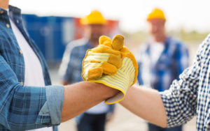 close up shot of construction contractors clasping hands as a sign of respect or teamwork