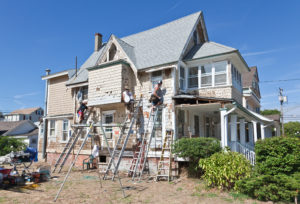 a two story home receiving home remodeling on its back face