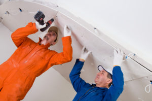 two construction workers working on home addition