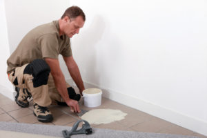 carpet and tile being installed in a bedroom by a contractor