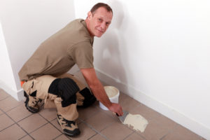 a man placing carpet and tile on a home's flooring